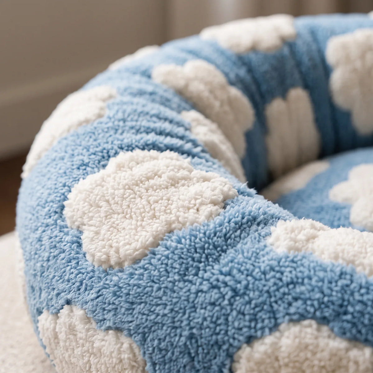 Gros plan sur le tissu doux et le rebord rembourré du panier anti-stress bleu à motif nuages