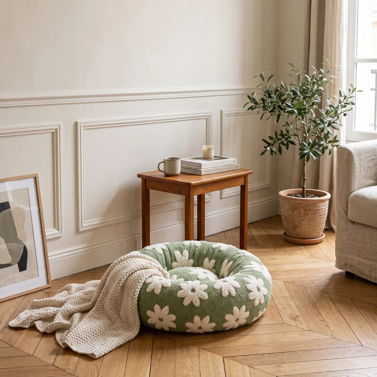 Panier rond anti-stress vert à pâquerettes installé dans un coin déco avec plaid et plante