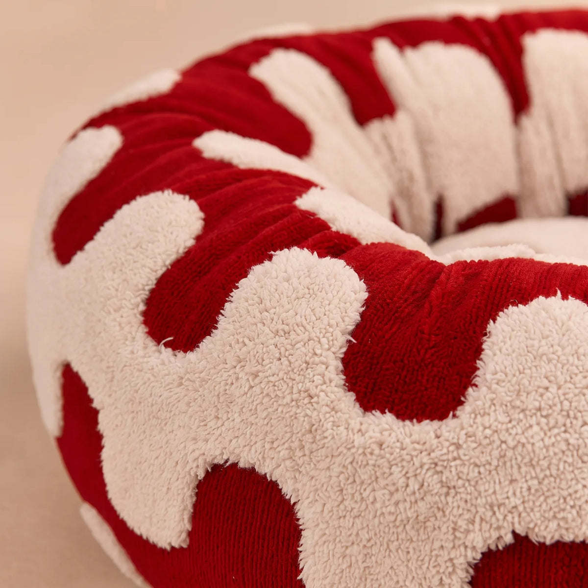 Gros plan sur le tissu doux et le rebord rembourré du panier anti-stress rouge à motif vagues
